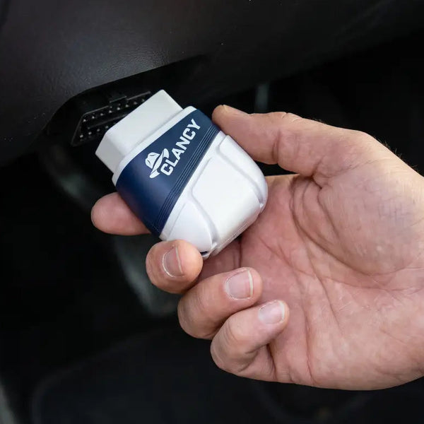 Clancy plugged into a car's OBD2 port under the dashboard
